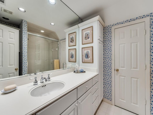 bathroom featuring tile patterned flooring, vanity, and an enclosed shower