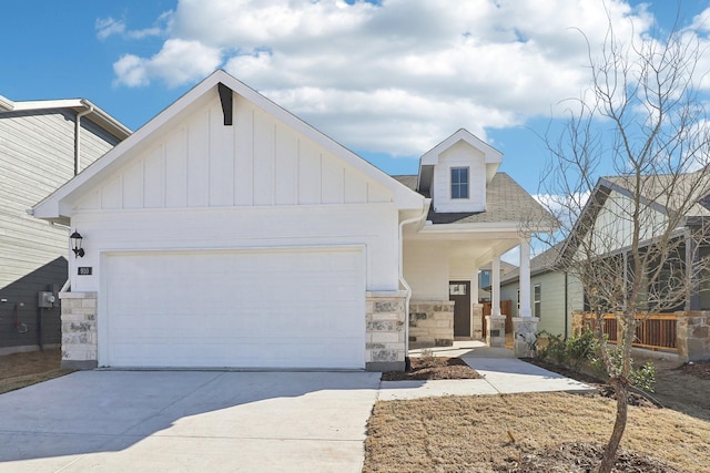 view of front facade with stone siding, board and batten siding, concrete driveway, and an attached garage