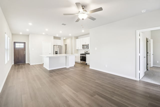 unfurnished living room with sink, ceiling fan, and light wood-type flooring