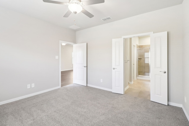 unfurnished bedroom with connected bathroom, light colored carpet, and ceiling fan