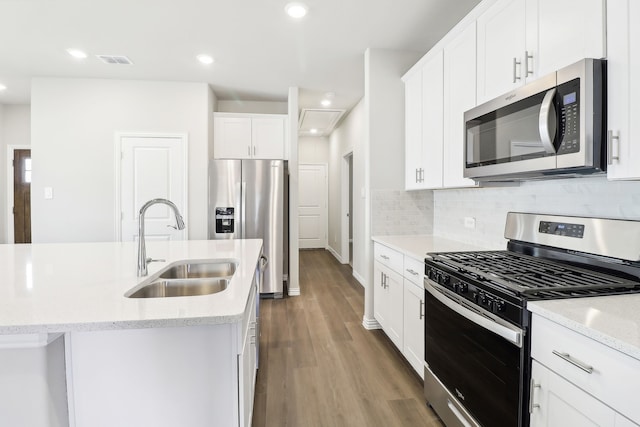 kitchen with appliances with stainless steel finishes, sink, a center island with sink, and white cabinets