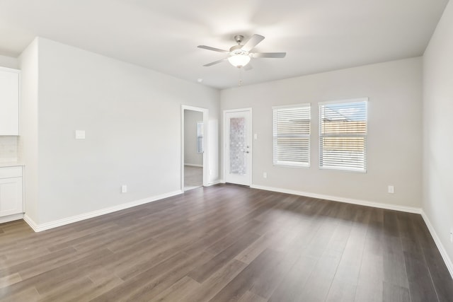 empty room with dark hardwood / wood-style flooring and ceiling fan