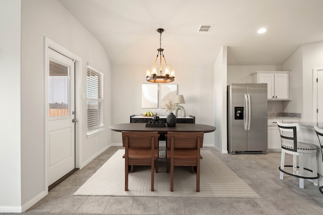 dining room with an inviting chandelier and vaulted ceiling