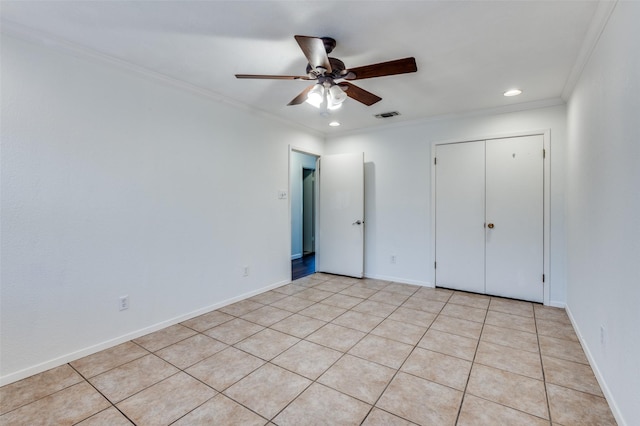 unfurnished bedroom featuring crown molding, light tile patterned floors, ceiling fan, and a closet