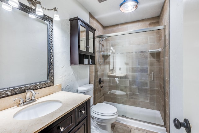 bathroom featuring an enclosed shower, vanity, tile patterned flooring, and toilet