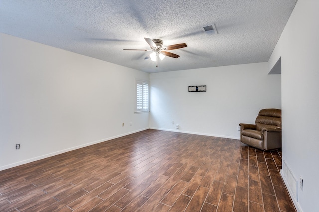 unfurnished room with dark wood-type flooring, a textured ceiling, and ceiling fan