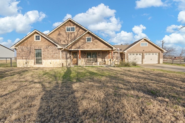 craftsman-style house featuring a garage, covered porch, and a front lawn