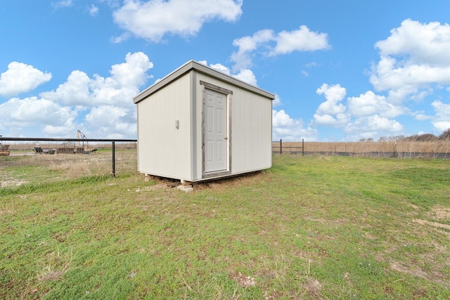 view of outbuilding featuring a yard and a rural view