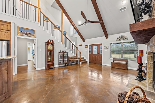 foyer featuring ceiling fan, high vaulted ceiling, a stone fireplace, and beamed ceiling