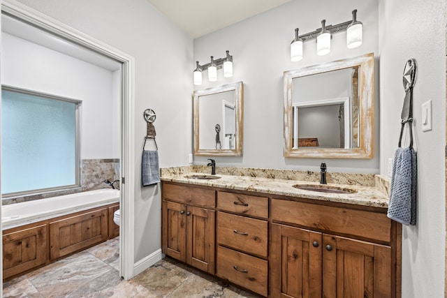 bathroom with a bathtub, vanity, and toilet