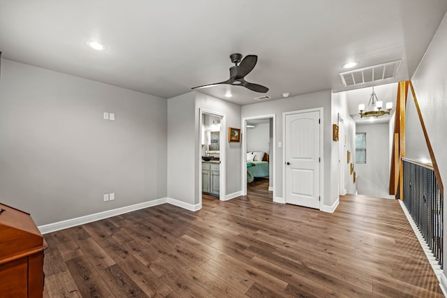 interior space featuring ceiling fan with notable chandelier and dark hardwood / wood-style flooring