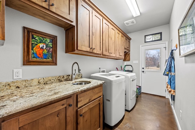 laundry room featuring cabinets, sink, and separate washer and dryer