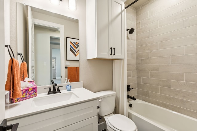 full bathroom featuring tiled shower / bath, vanity, and toilet