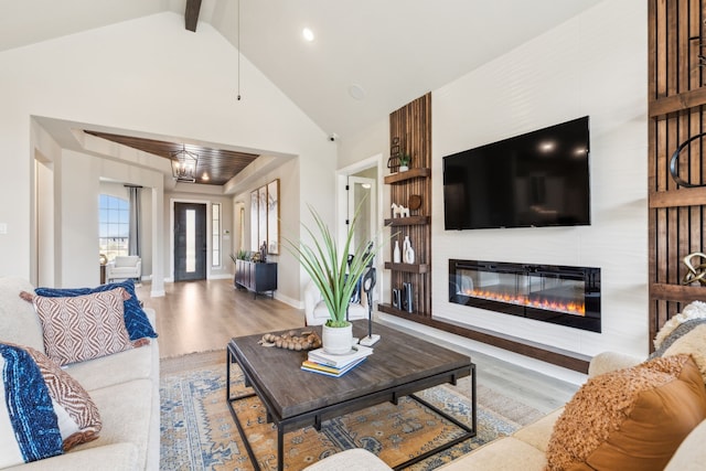 living room with light hardwood / wood-style flooring and high vaulted ceiling