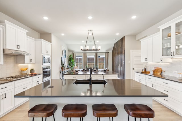 kitchen featuring stainless steel appliances, sink, a kitchen island with sink, and a breakfast bar area