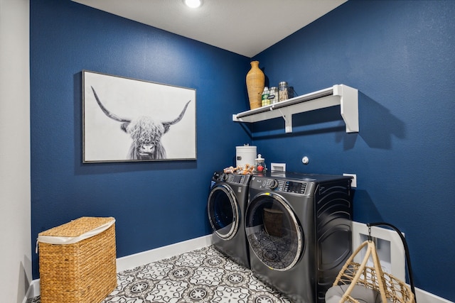 clothes washing area featuring tile patterned flooring and washing machine and clothes dryer