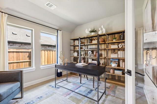 home office featuring lofted ceiling and light hardwood / wood-style flooring