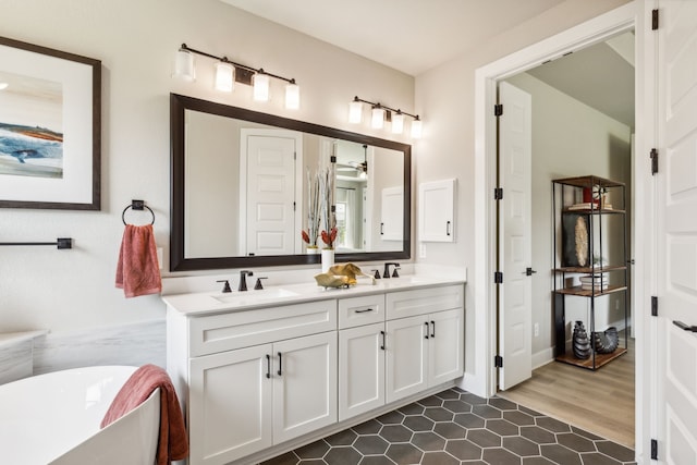 bathroom featuring ceiling fan, vanity, and a bath