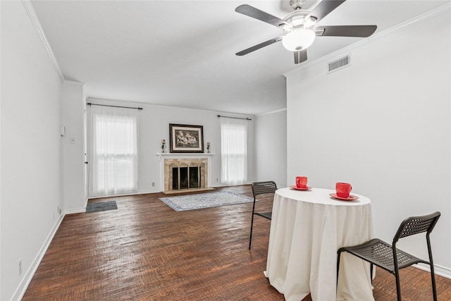 dining room with dark hardwood / wood-style flooring, ornamental molding, ceiling fan, and a high end fireplace