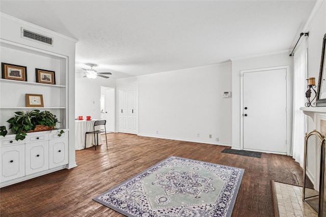 entrance foyer featuring dark hardwood / wood-style flooring, ornamental molding, and ceiling fan