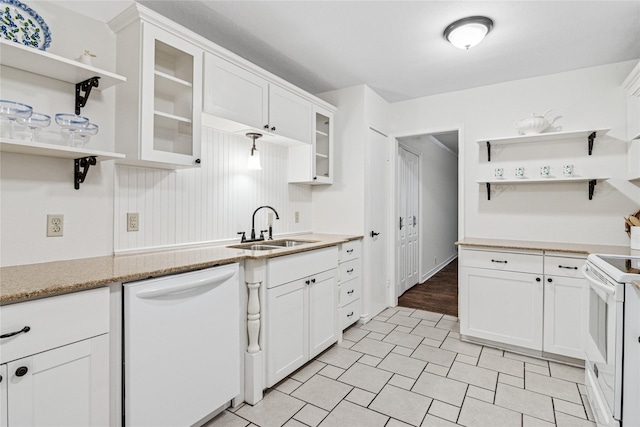 kitchen with white cabinetry, sink, white appliances, and light stone countertops