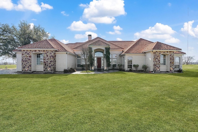 mediterranean / spanish house featuring a front lawn