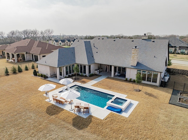 view of swimming pool featuring a patio area, a lawn, and an in ground hot tub