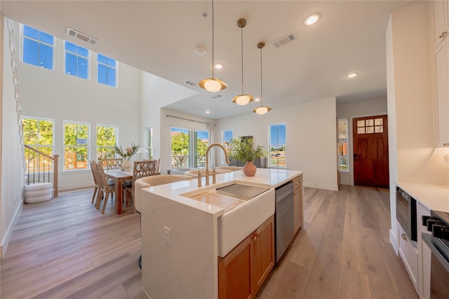 kitchen with baseboards, light countertops, appliances with stainless steel finishes, light wood-style floors, and recessed lighting