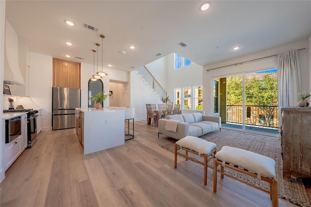 bedroom featuring freestanding refrigerator, light wood-type flooring, visible vents, recessed lighting, and access to exterior