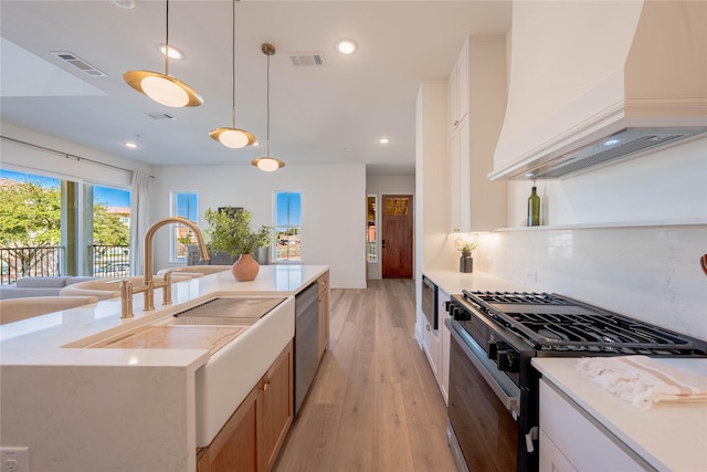kitchen with custom exhaust hood, dishwasher, black gas range, and visible vents