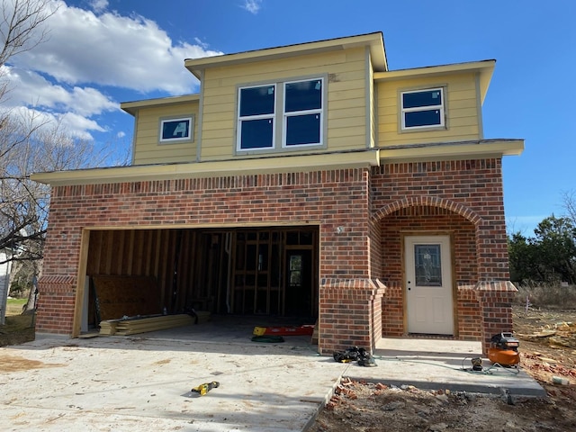 view of front of home featuring brick siding and driveway