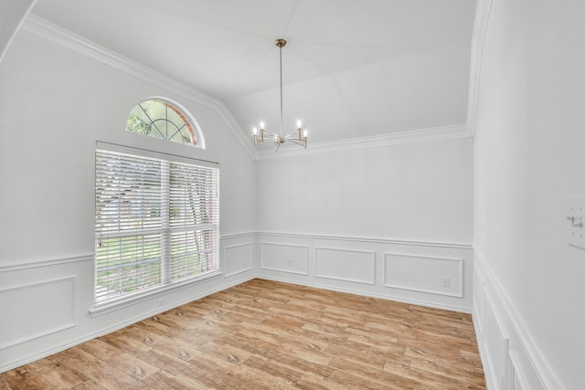 spare room featuring an inviting chandelier, crown molding, light wood-type flooring, and vaulted ceiling