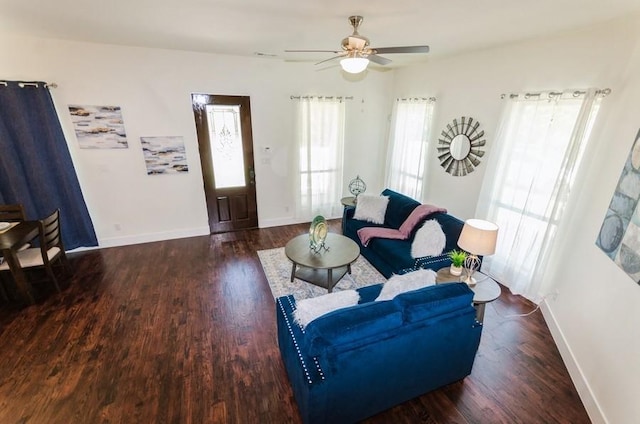 living room featuring ceiling fan, baseboards, and wood finished floors