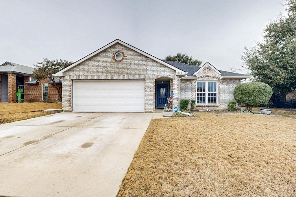 ranch-style home with a garage and a front yard