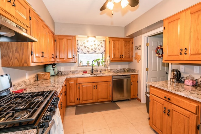 kitchen featuring sink, light tile patterned floors, appliances with stainless steel finishes, ceiling fan, and light stone countertops