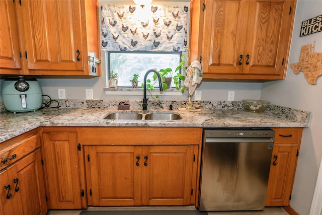 kitchen with sink, stainless steel dishwasher, and light stone countertops