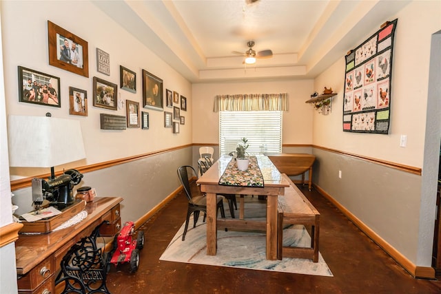 dining space featuring a raised ceiling and ceiling fan