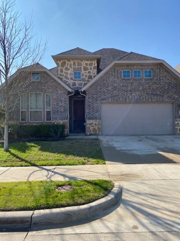 view of front of property with a garage and a front yard