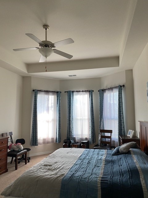 bedroom featuring carpet flooring, ceiling fan, and a tray ceiling