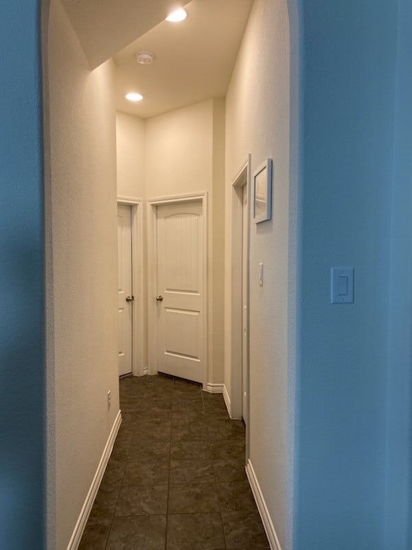 hall with dark tile patterned floors