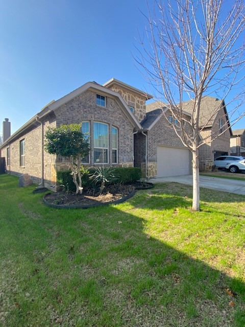 view of front of property featuring a garage and a front lawn