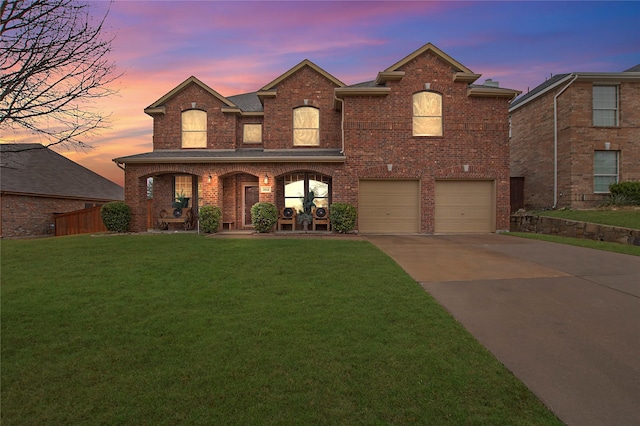 front of property featuring a garage, a porch, and a yard