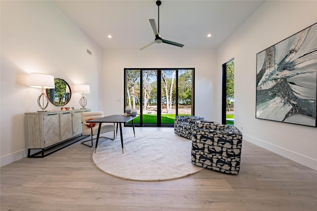 living area featuring wood-type flooring and ceiling fan