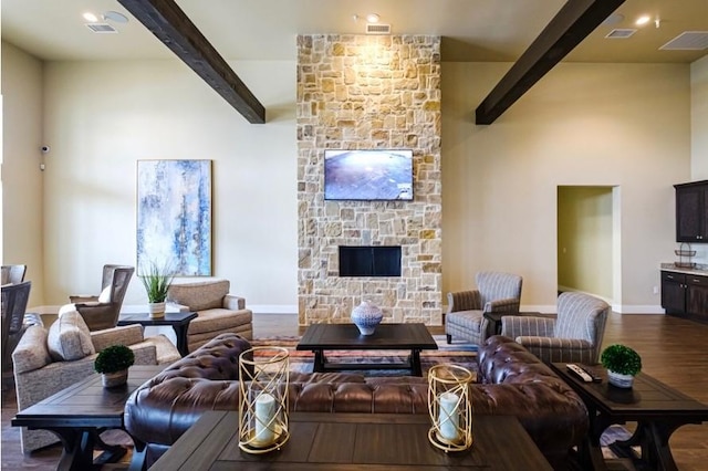 living room featuring beamed ceiling, dark hardwood / wood-style floors, and a fireplace