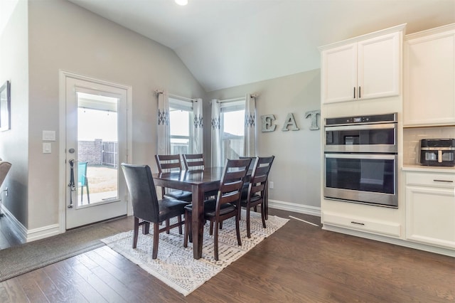 dining space with vaulted ceiling and dark hardwood / wood-style floors