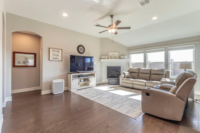 living room featuring a fireplace, vaulted ceiling, dark hardwood / wood-style floors, and ceiling fan