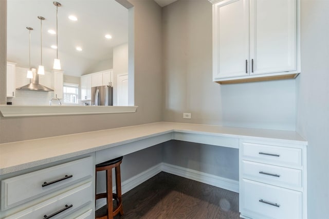 unfurnished office with dark wood-type flooring, built in desk, and vaulted ceiling