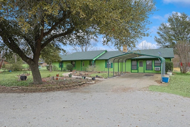 ranch-style home with driveway, a front yard, and a detached carport