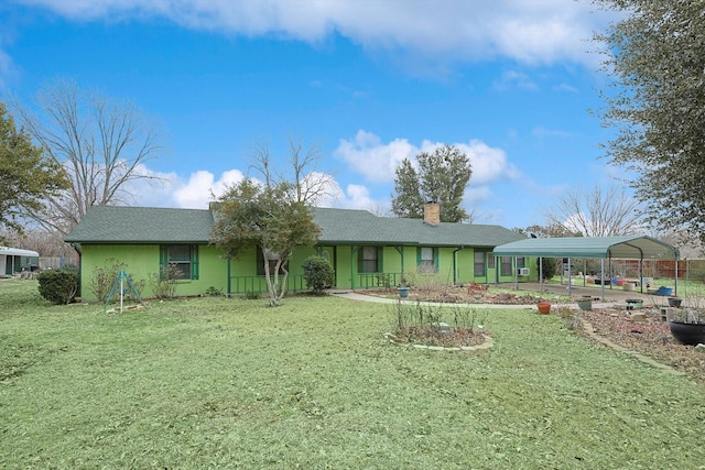 back of house featuring a carport, a chimney, and a lawn