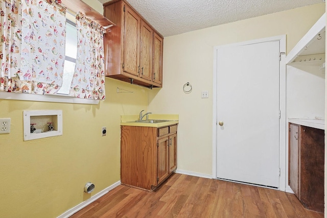 1806 Duck Creek Rd, Sanger, TX 76266 - laundry area with hookup for a washing machine, a sink, light wood-style floors, cabinet space, and baseboards